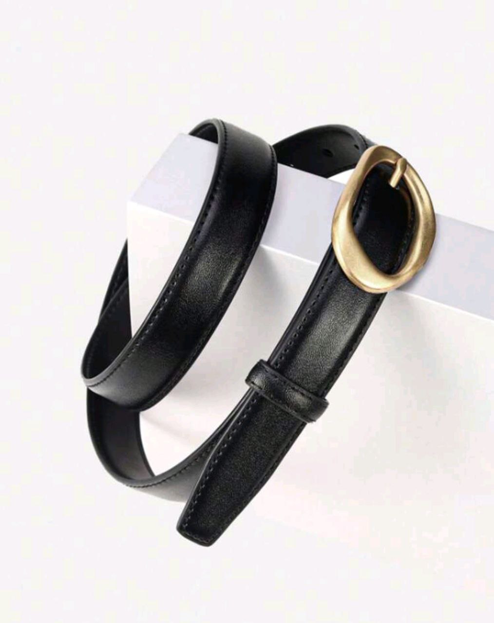 Black belt with a gold buckle on a white background