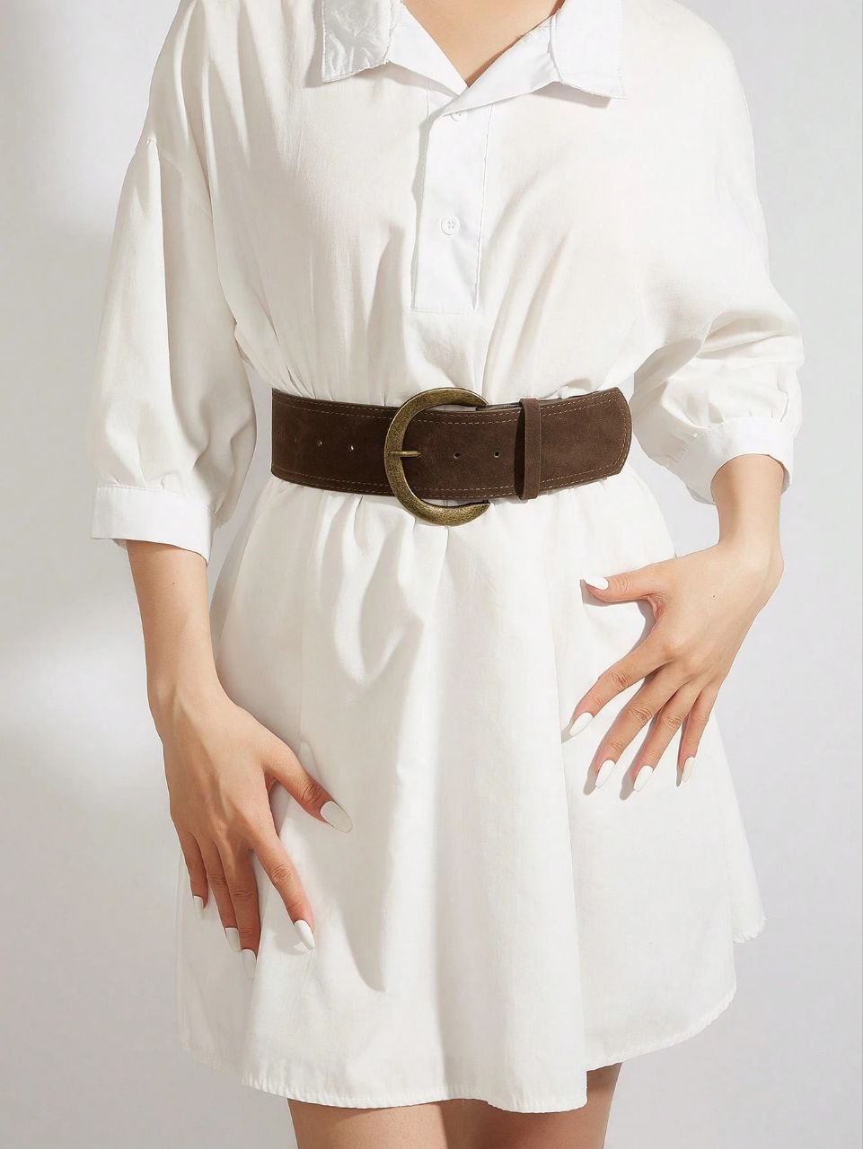 White dress with a brown belt on a plain background