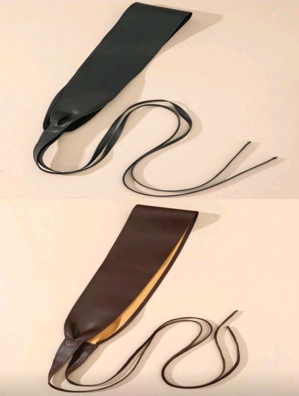 Two leather belts on a beige background