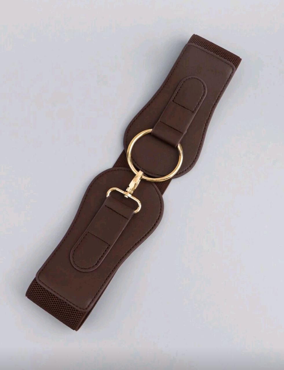 Brown leather girth strap with gold hardware on a light gray background