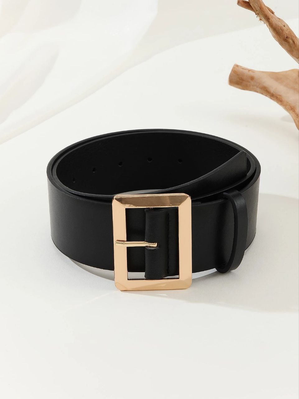 Black belt with a gold buckle on a white background