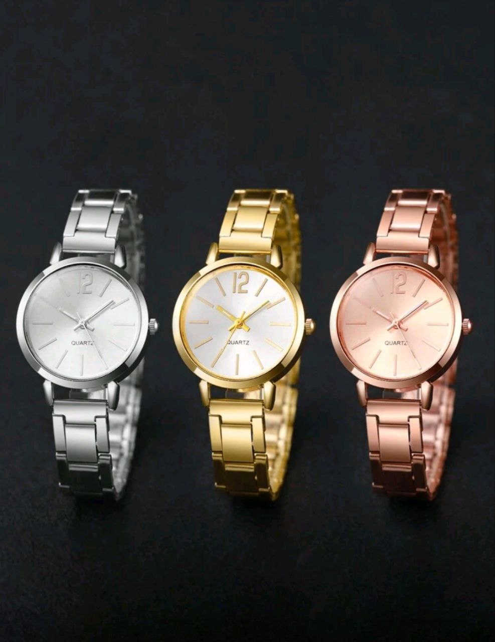 Three watches in silver, gold, and rose gold on a dark background